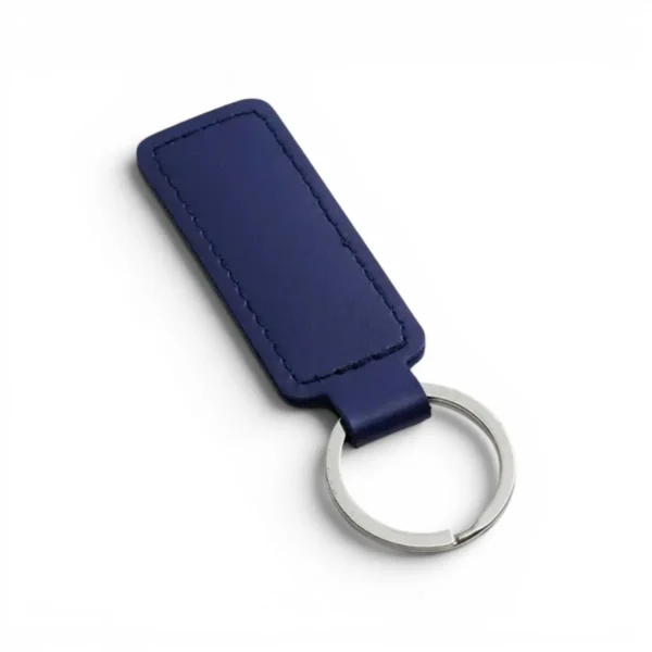 wikxy-laser-engraved-leather-keyholder-rectangular-shape-dark-blue A dark blue, blank premium leather keyholder before customisation, showcasing the raw stitching and thick leather grain on a wooden workshop table by WIKXY.