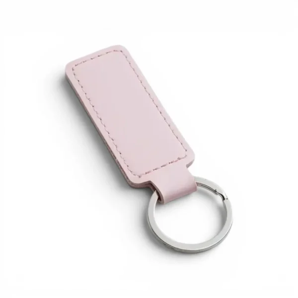 wikxy-laser-engraved-leather-keyholder-rectangular-shape-light-pink A pink colour, blank premium leather keyholder before customisation, showcasing the raw stitching and thick leather grain on a wooden workshop table by WIKXY.